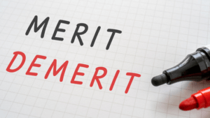 ノートにかかれた「MERIT」「DEMERIT」の文字と2本のペン。