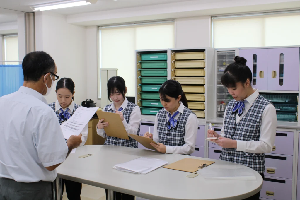 校内医療実習で来院者への対応を行う医療事務科の学生